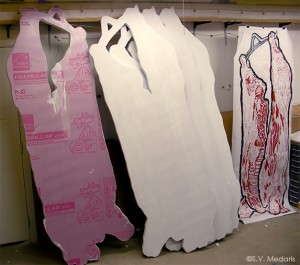 The steps shown in making of a woodcut printed hanging carcass, with pink foam board on left, and prints on right